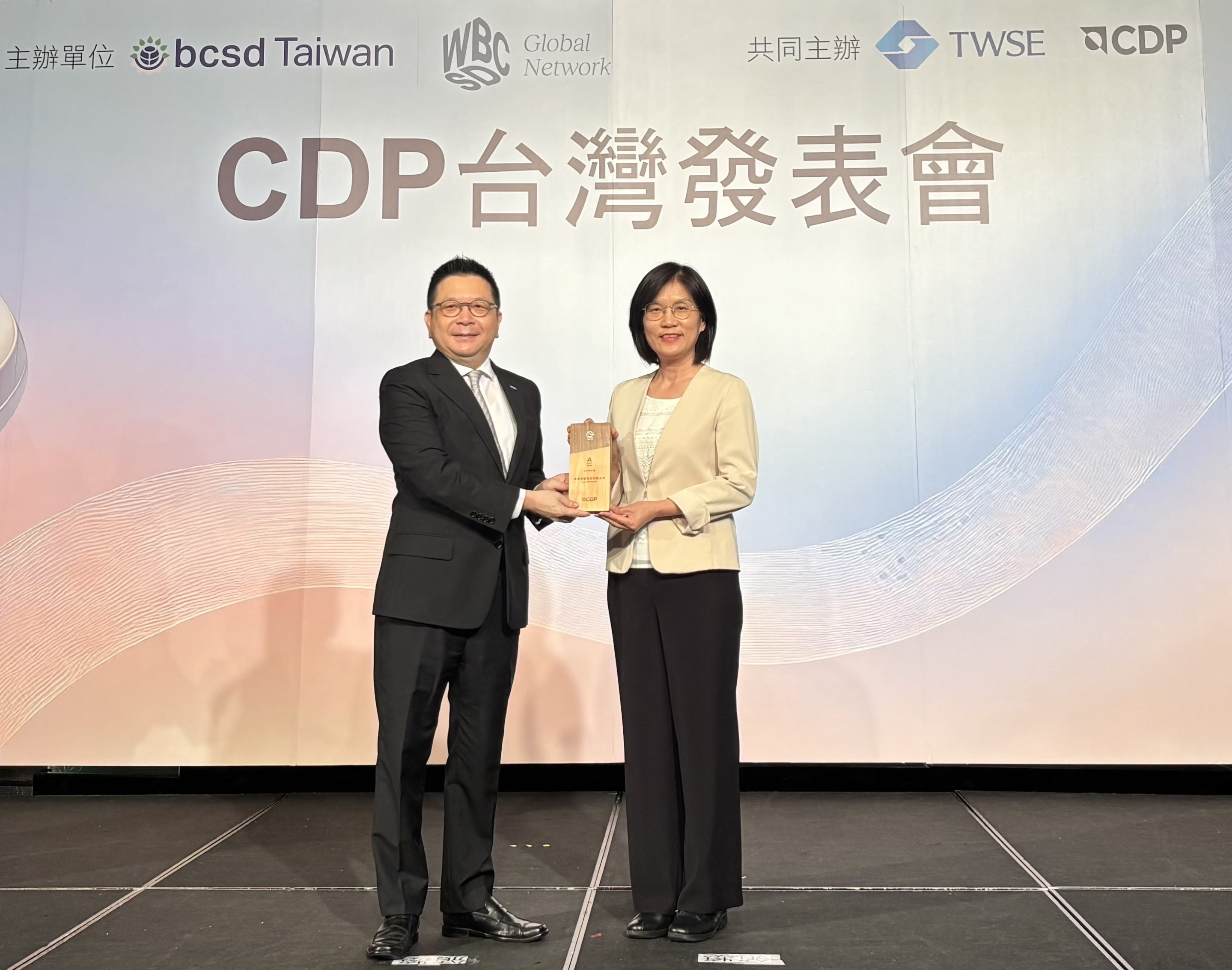 友達永續成果再獲國際評比肯定，獲頒CDP氣候與水資源雙項領導力評級。今由臺灣證券交易所董事長林修銘（左）頒獎，友達光電永續長古秀華（右）代表受獎